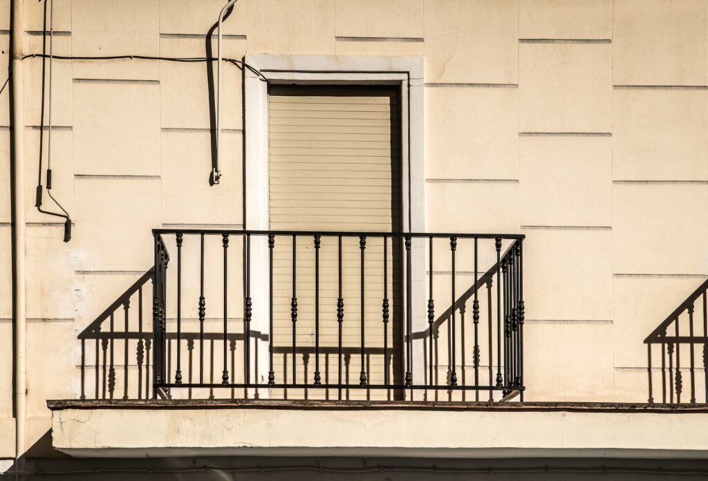 Balcon de un edificio con una barandilla pintada de negro.