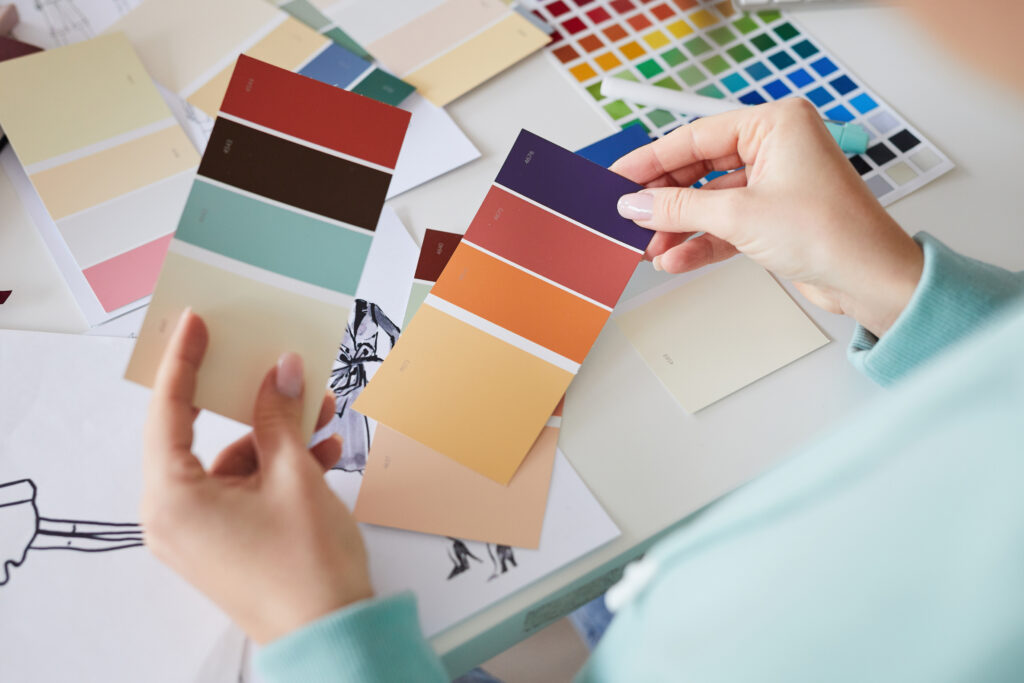 Primer planode una persona sentada en la mesa y mirando muestras de color.